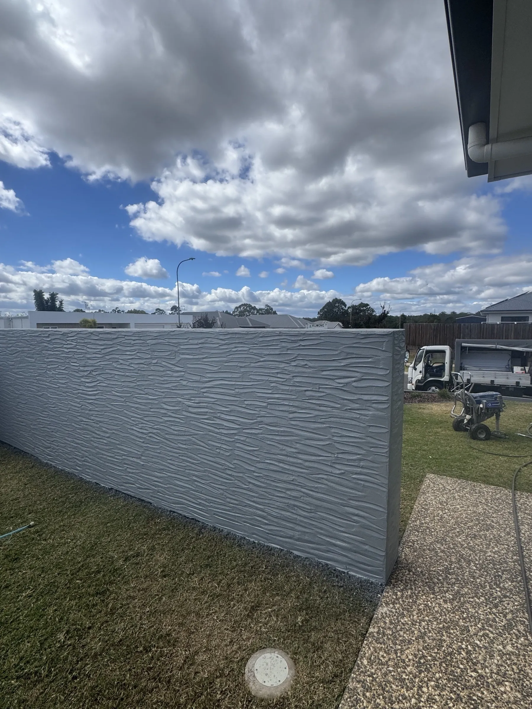 Custom grey fence run with the Superior Home Improvements work vehicle parked on-site, showing a residential fence job in the Darling Downs