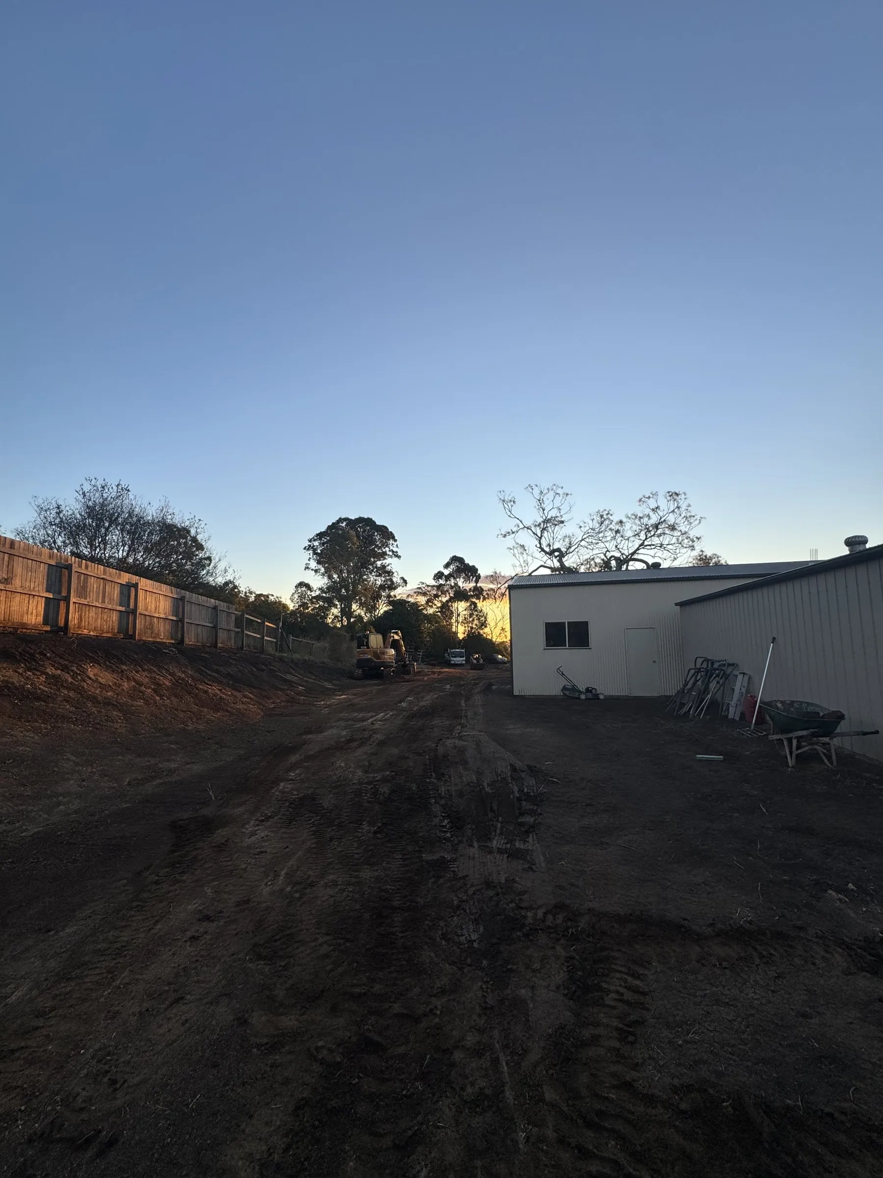 A loaded trailer on a cleared rural property at dusk during a site clean-up and rubbish removal job in the Southern Downs